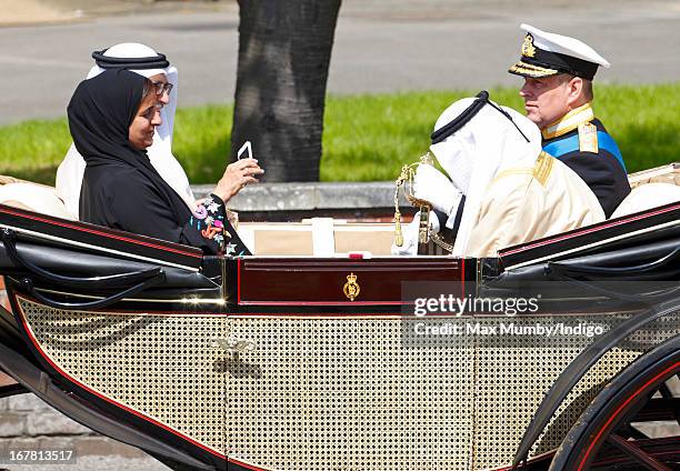 Sheikha Lubna Al-Qasimi, UAE Minister of Foreign Trade, photographs Prince Andrew, Duke of York using an iPhone as they travel in a horse drawn...