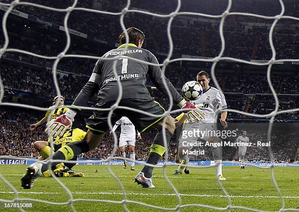 Karim Benzema of Real Madrid scores the opening goal past Roman Weidenfeller of of Borussia Dortmund during the UEFA Champions League Semi Final...