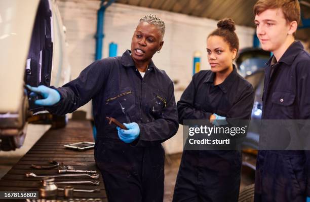 female auto mechanic tutor with students - trainer stockfoto's en -beelden