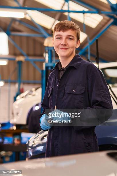 car mechanic apprentice in the workshop - hand tool stock pictures, royalty-free photos & images