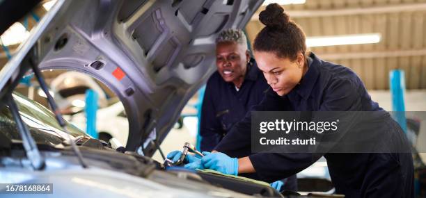 female auto mechanic tutor with daughter apprentice - hand tool stock pictures, royalty-free photos & images