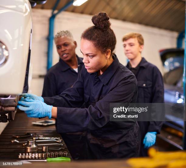 female auto mechanic apprentice in traning class - auto stock pictures, royalty-free photos & images