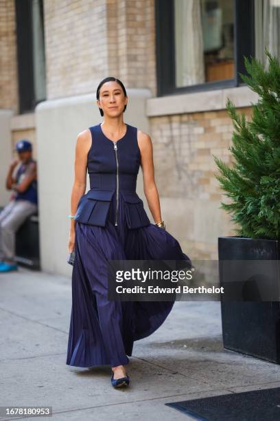 Eva Chen wears a blue sleeveless dress with large pockets and a bottom pleated part designed as a skirt, ballerina shoes, outside Brandon Maxwell,...