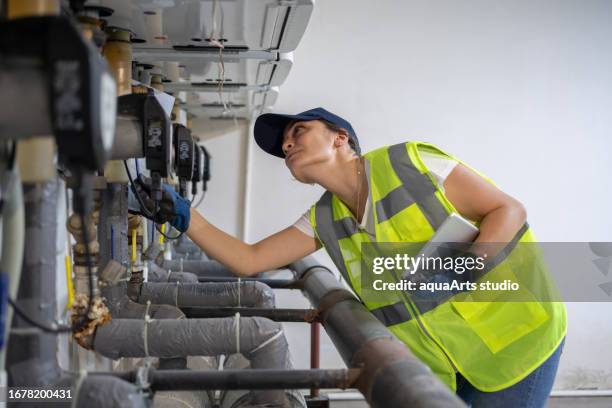 female engineer checking boiler system in a basement - district heating plant stock pictures, royalty-free photos & images