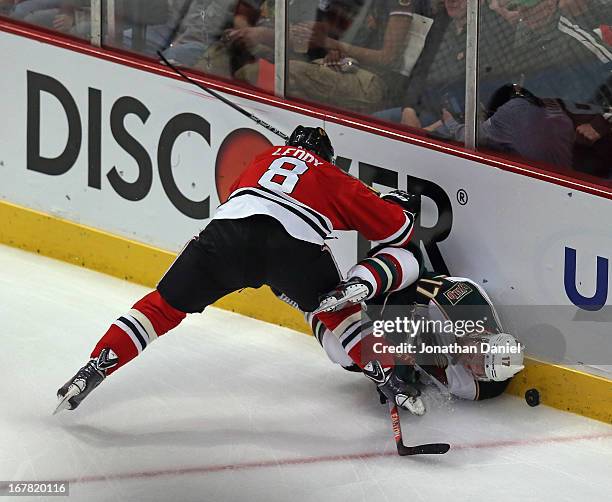 Nick Leddy of the Chicago Blackhawks checks Torrey Mitchell of the Minnesota Wild in Game One of the Western Conference Quarterfinals during the 2013...