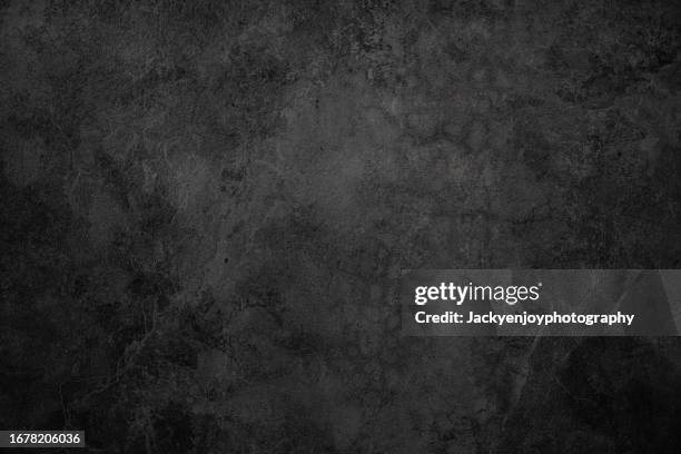 concrete wall texture in black with an aged, grungy wall colour. - mur de pierres photos et images de collection