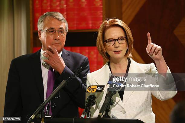 Australian Prime Minister Julia Gillard talks to the media as Treasurer Wayne Swan looks on during a press conference at the Commonwealth...