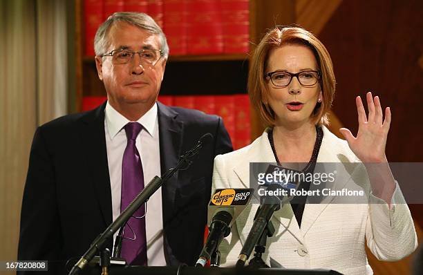 Australian Prime Minister Julia Gillard talks to the media as Treasurer Wayne Swan looks on during a press conference at the Commonwealth...