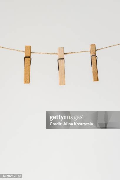 wooden clothespins hang on rope on gray background - clothespin string stock pictures, royalty-free photos & images