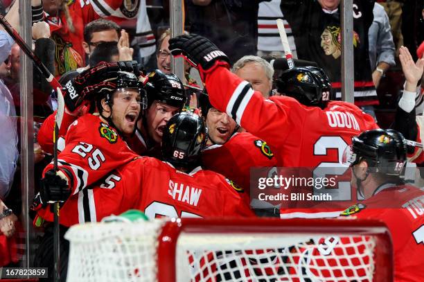 Bryan Bickell of the Chicago Blackhawks celebrates with teammates, including Viktor Stalberg and Michal Rozsival, after scoring the game winning goal...