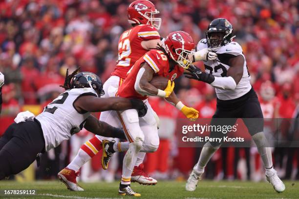 Isiah Pacheco of the Kansas City Chiefs is tackled by DaVon Hamilton of the Jacksonville Jaguars during an AFC Divisional Round playoff game against...