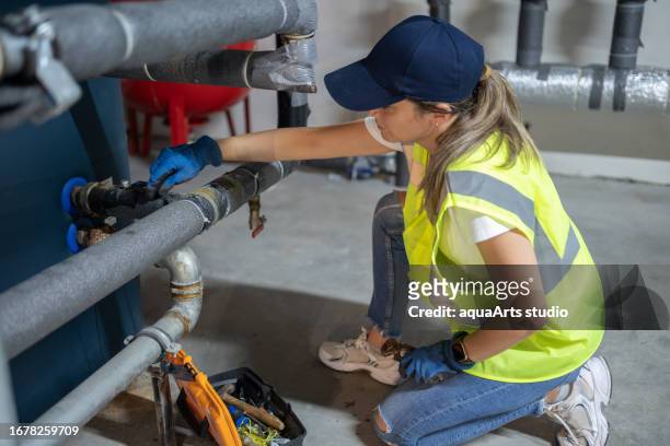 female engineer checking boiler system in a basement - district heating plant stock pictures, royalty-free photos & images