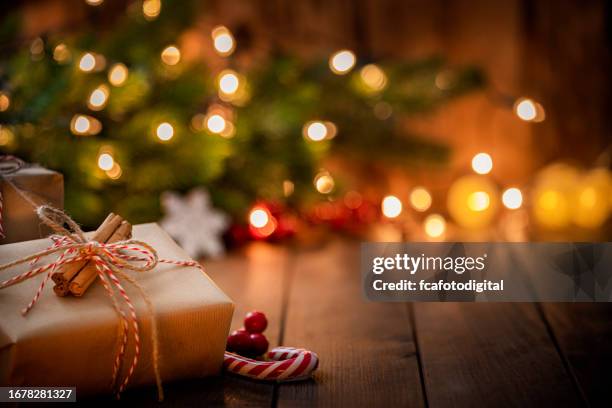 brown christmas gift box on rustic wooden table. - holiday lights stock pictures, royalty-free photos & images