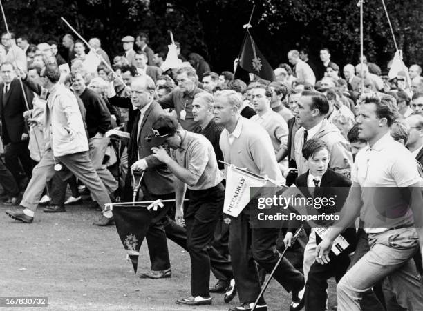 Jack Nicklaus of the United States and Gary Player of South Africa are followed by a huge gallery of spectators during the final round of the...