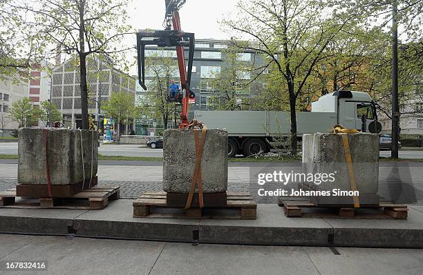 Crane lowers concrete barricades around the Oberlandgericht Muenchen state courthouse a week before the NSU trial on April 30, 2013 in Munich,...