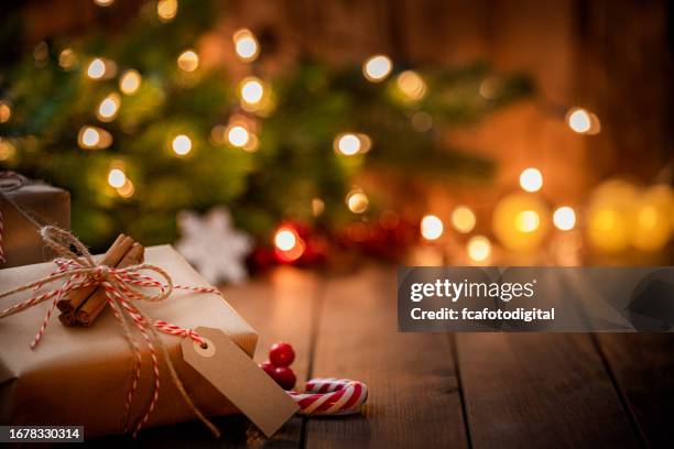 caja de regalo de navidad marrón con una etiqueta en blanco en una mesa de madera rústica. - feliz navidad fotografías e imágenes de stock