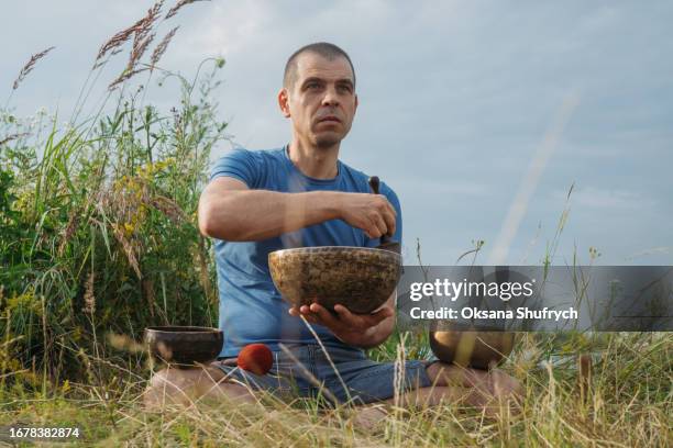 man uses tibetian bowls on nature - concentration camp stock pictures, royalty-free photos & images