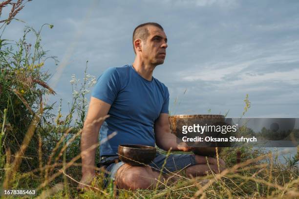 man uses tibetian bowls on nature - concentration camp stock pictures, royalty-free photos & images