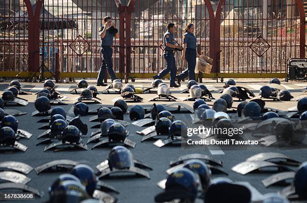 Police officers pass by rows of shields and helmets near the presidential palace on May 1, 2013 in Manila, Philippines. Philippines workers unions...