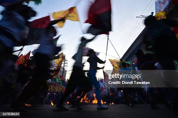 Protestors cricle around a burning effigy of Philippine president Benigno Aquino and US president Barack Obama on May 1, 2013 in Manila, Philippines....