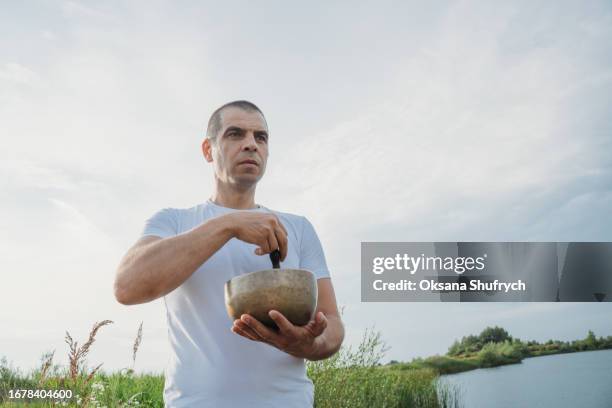 man uses tibetian bowls on nature - concentration camp stock pictures, royalty-free photos & images