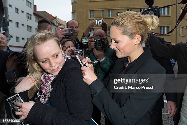 German singer Helene Fischer signs an autograph on the back of a fan prior to the premiere of the documentary 'Allein im Licht' at the Babylon cinema...