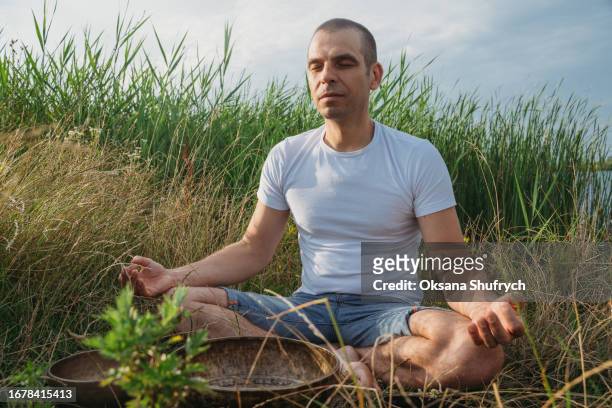 man uses tibetian bowls on nature - concentration camp stock pictures, royalty-free photos & images