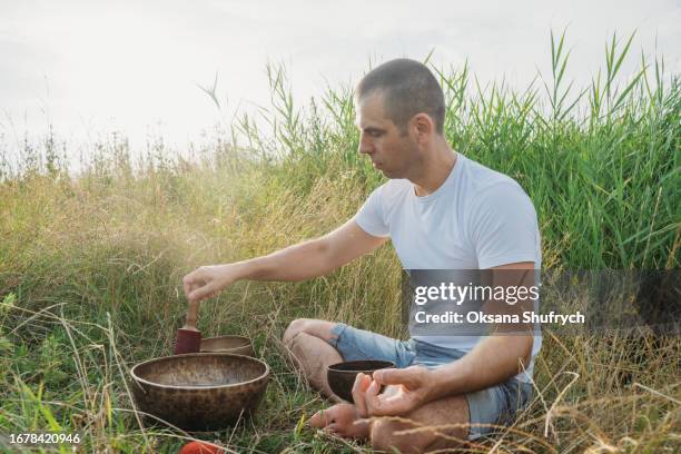 man uses tibetian bowls on nature - concentration camp stock pictures, royalty-free photos & images