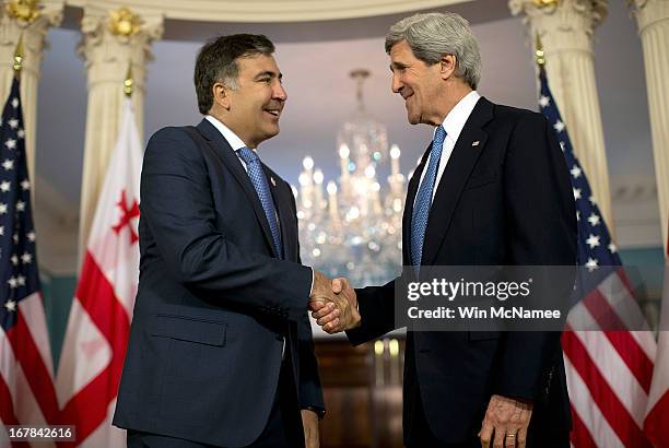 Secretary of State John Kerry shakes hands with the President of Georgia Mikheil Saakashvili after speaking to journalists following a bilateral...
