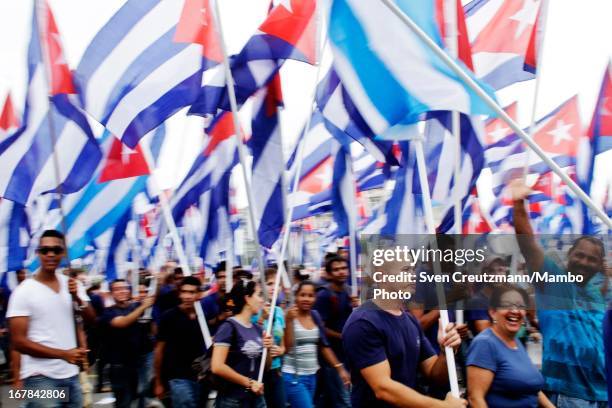 Cubans march holding hundreds of Cuban flags as closing the annual May Day parade of hundreds of Cubans at the Revolution Square on May 1, 2013 in...