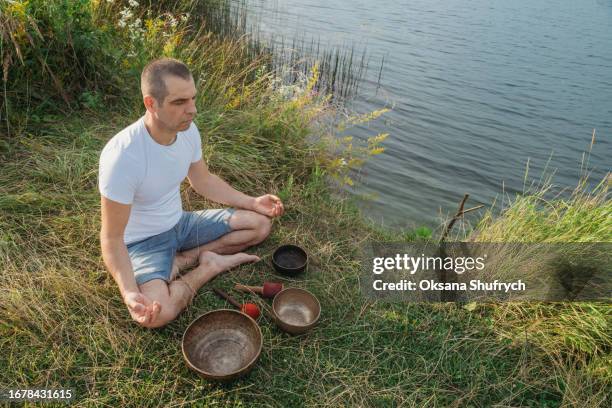 man uses tibetian bowls on nature - concentration camp stock pictures, royalty-free photos & images