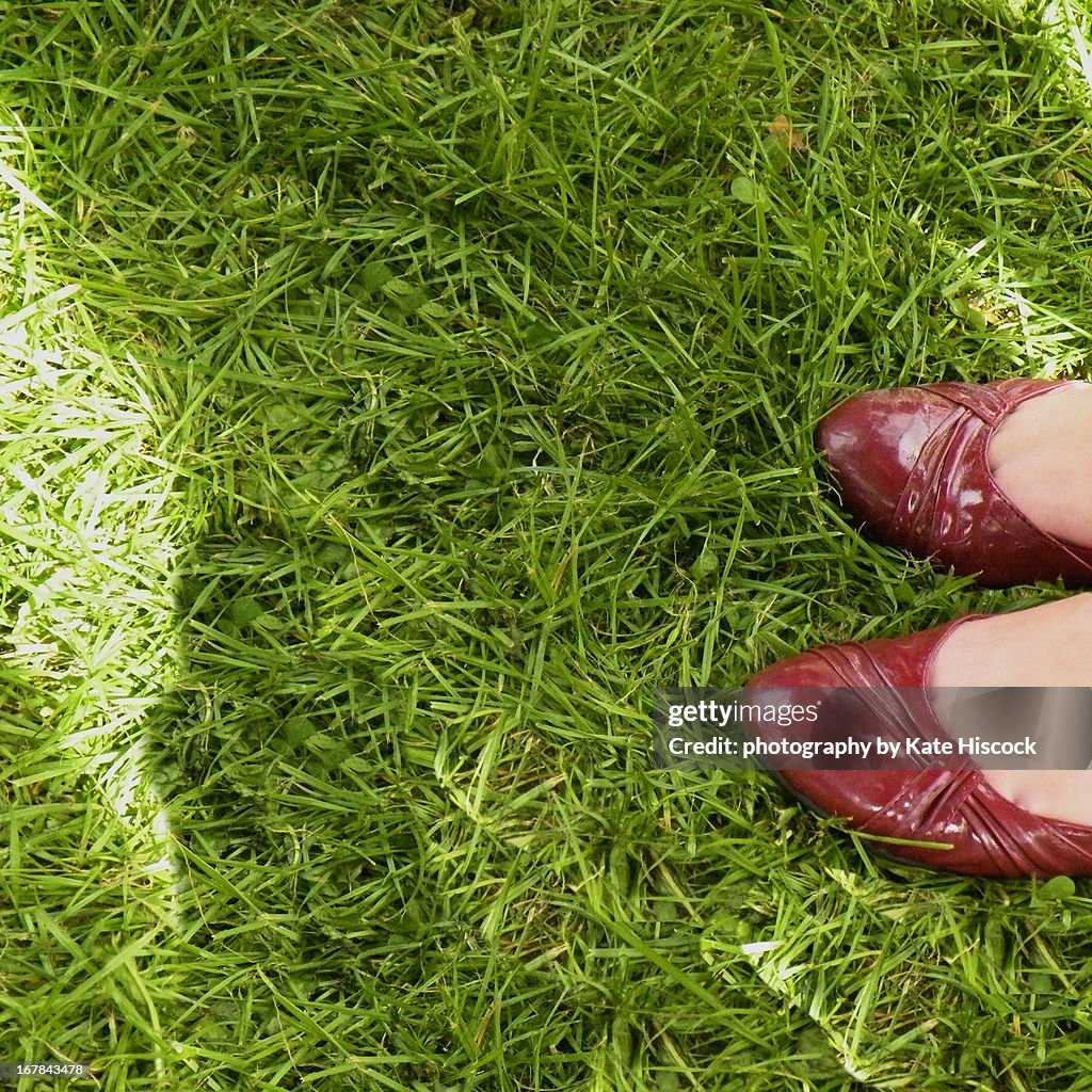 Women in red shoes on grass on a sunny day