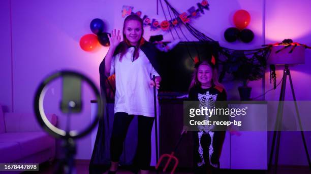 mother and daughter enjoying dancing and live streaming during halloween in living room at home - live action role playing bildbanksfoton och bilder