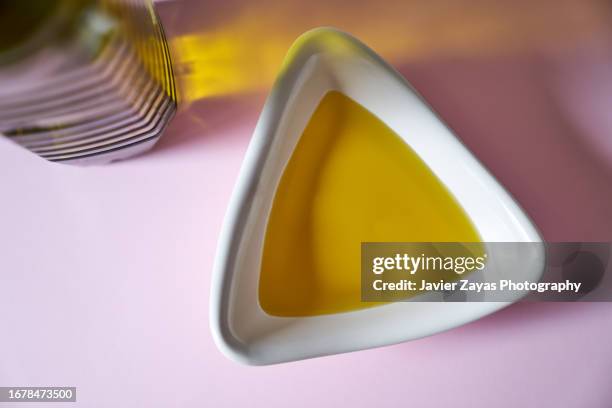 bowl with olive oil on pink background - price gouging stock pictures, royalty-free photos & images