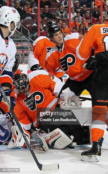 Ilya Bryzgalov and Oliver Lauridsen of the Philadelphia Flyers protects the loose puck against the New York Islanders on April 25, 2013 at the Wells...