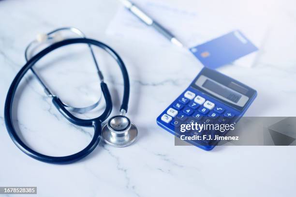 blue credit card next to stenoscope and calculator - formulario de reclamación fotografías e imágenes de stock