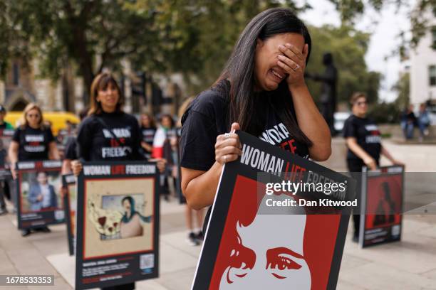 Woman reacts as she takes part in a protest ahead of the first anniversary of the death of Mahsa Amini, on September 13, 2023 in London, England....