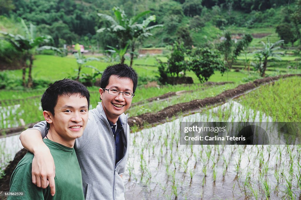 Two men in front of a rice paddy