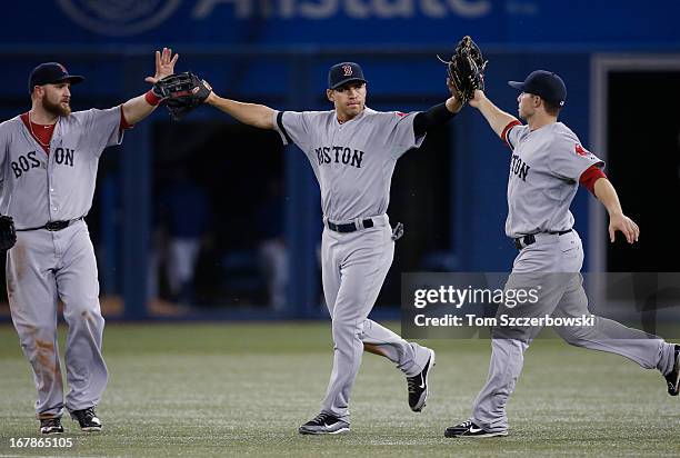 Jacoby Ellsbury of the Boston Red Sox celebrates with Jonny Gomes and Daniel Nava after their victory during MLB game action against the Toronto Blue...
