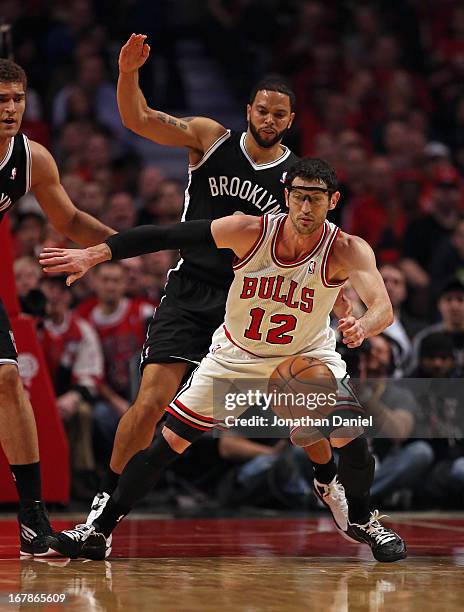 Kirk Hinrich of the Chicago Bulls tries to control the ball under pressure from Deron Williams of the Brooklyn Nets in Game Three of the Eastern...