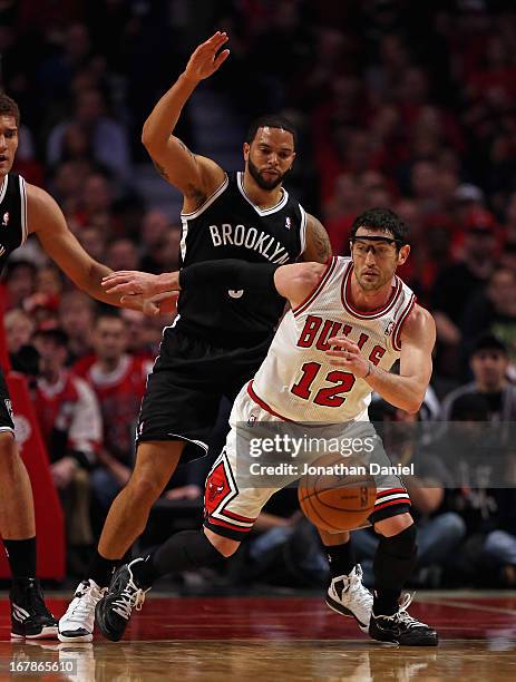 Kirk Hinrich of the Chicago Bulls tries to control the ball under pressure from Deron Williams of the Brooklyn Nets in Game Three of the Eastern...