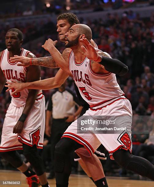 Carlos Boozer of the Chicago Bulls boxes out on Brook Lopez of the Brooklyn Nets in Game Three of the Eastern Conference Quarterfinals during the...