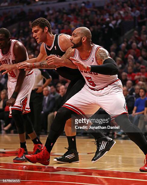 Carlos Boozer of the Chicago Bulls boxes out on Brook Lopez of the Brooklyn Nets in Game Three of the Eastern Conference Quarterfinals during the...