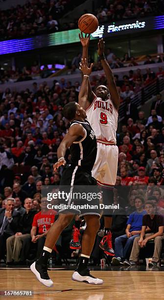 Loul Deng of the Chicago Bulls shoots over Joe Johnson of the Brooklyn Nets in Game Three of the Eastern Conference Quarterfinals during the 2013 NBA...