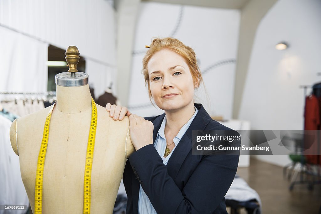 Seamstress leaning against a mannequin.
