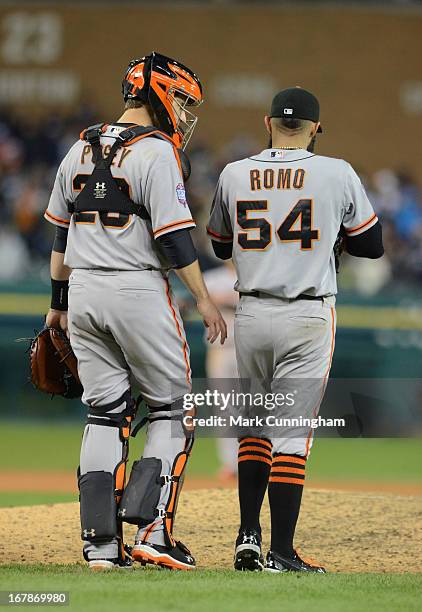 Buster Posey and Sergio Romo of the San Francisco Giants talk together on the pitchers mound during Game Three of the World Series against the...