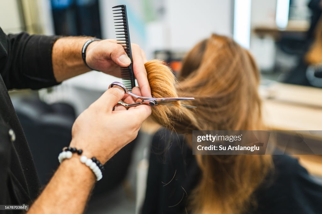 Beautiful young woman getting her hair cut