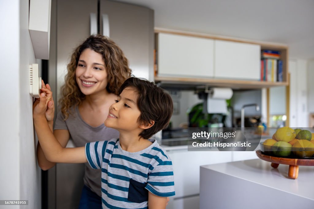 Mother and son adjusting the temperature of their house