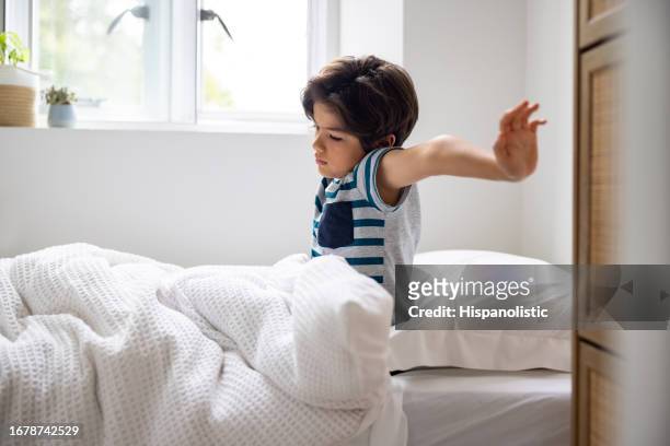 boy waking up in the morning and yawning in his bed - good morning stock pictures, royalty-free photos & images