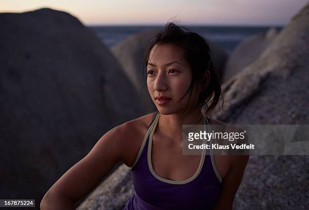 woman sitting on rock looking at sea - focus on sport 2013 stockfoto's en -beelden